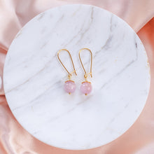 Ladda upp bild till gallerivisning, Elegant Kunzite earrings with details in 18k gold-plated 925 sterling silver. Presented on marble and pink silk fabric.